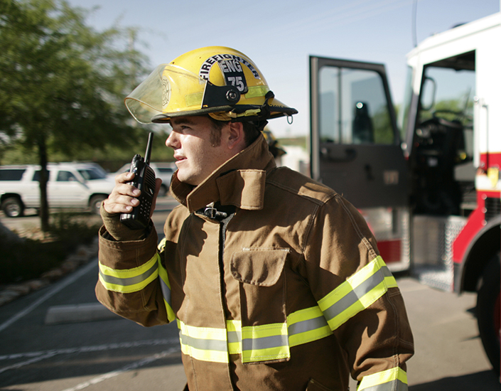 Firefighter talking on wireless portable radio